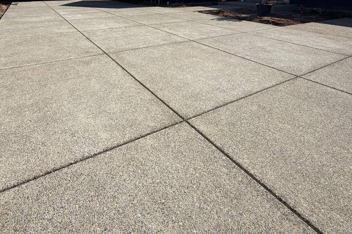 Finished concrete patio beside a pool on a foothill property