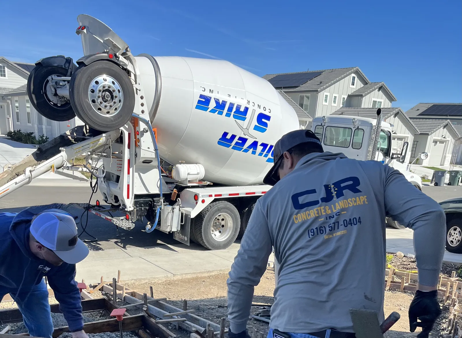 CJR crew finishing a concrete pour as a ready mix truck unloads in a new neighborhood