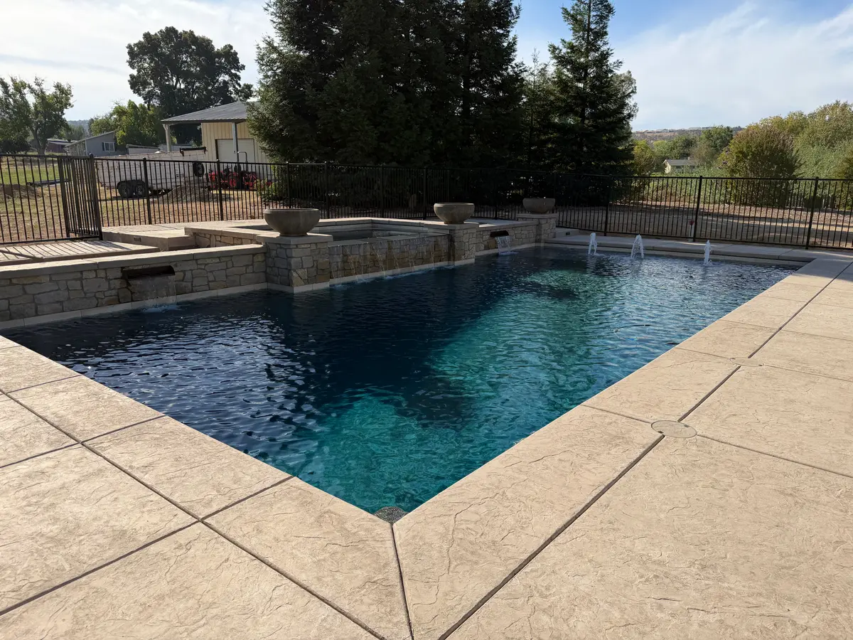 Custom pool with stone planter bowls and sheer descents project by CJR Concrete & Landscape Construction