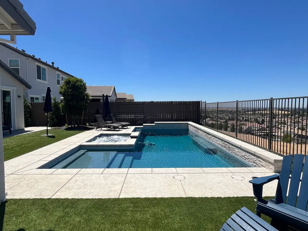 Pool and spa with artificial turf and a hillside view project by CJR Concrete & Landscape Construction