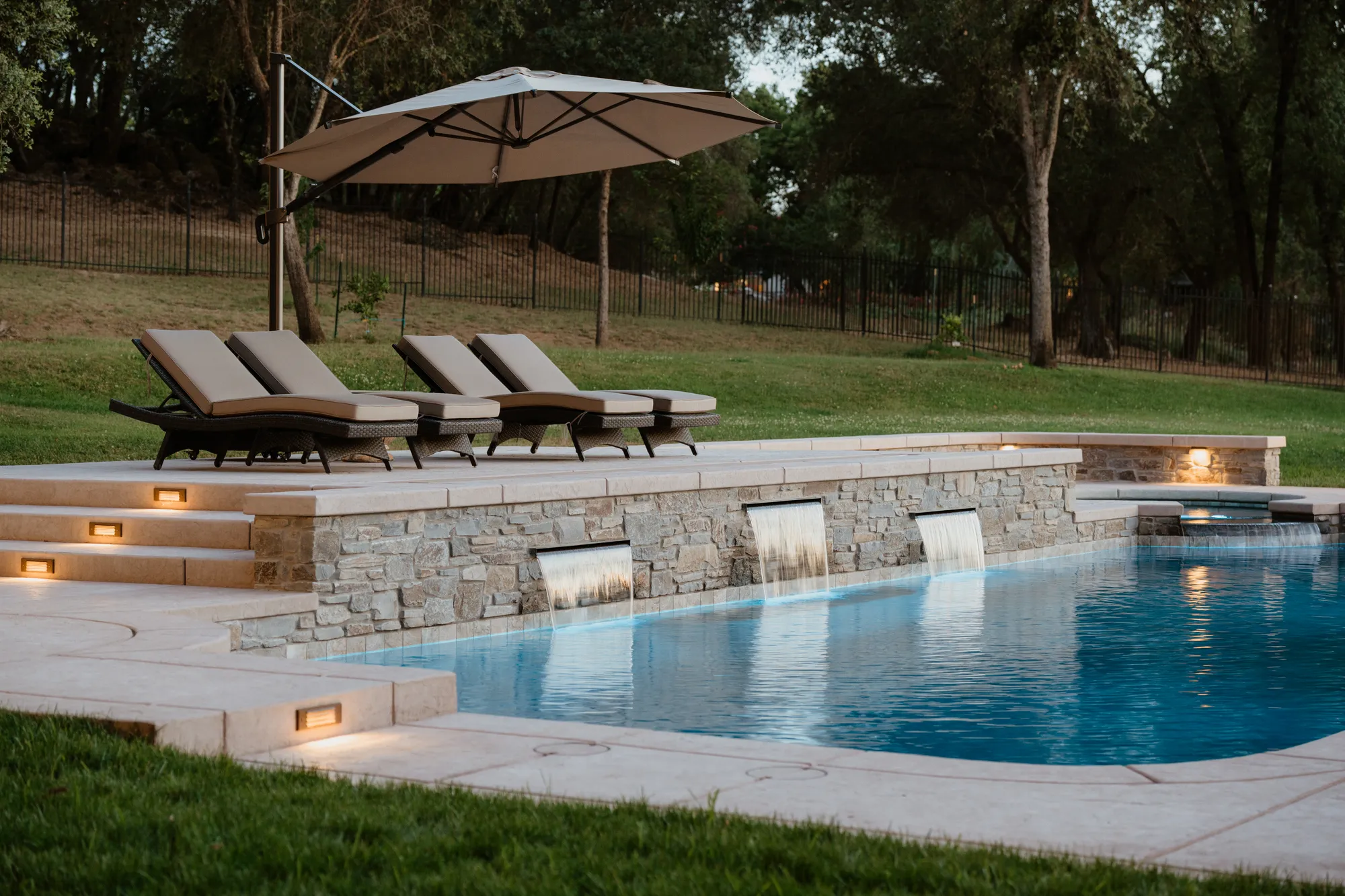 Custom pool with pergola and rock landscaping built by CJR in the greater Sacramento area